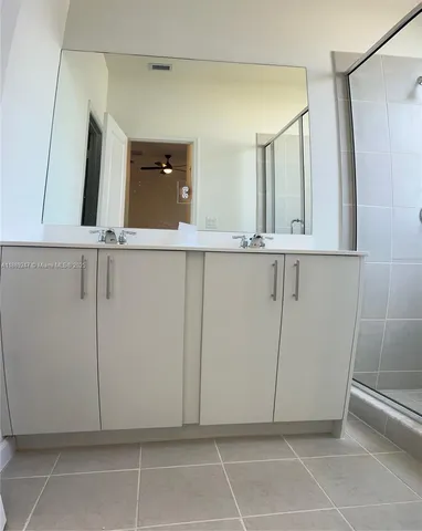 a view of a utility room with cabinets and a window