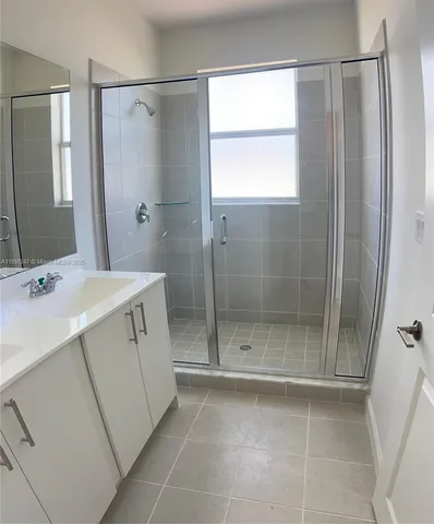 a bathroom with a shower sink and mirror