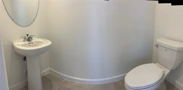a white toilet sitting next to a bathroom sink