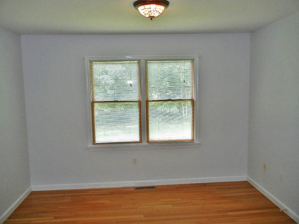 399 Bridge Road, Unit E Northampton, MA 01062 - Photo 6 of 17 a view of an empty room with wooden floor and a window