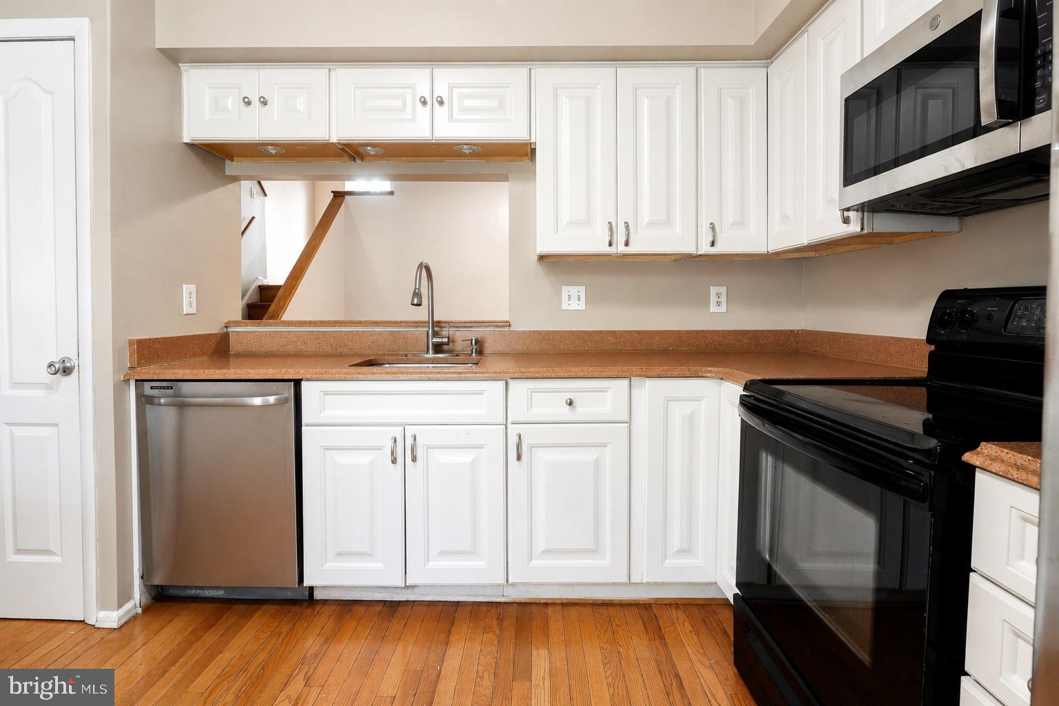 9054 Canterbury Riding, Unit 147 Laurel, MD 20723 - Photo 2 of 15 a kitchen with stainless steel appliances granite countertop a stove a sink and a microwave