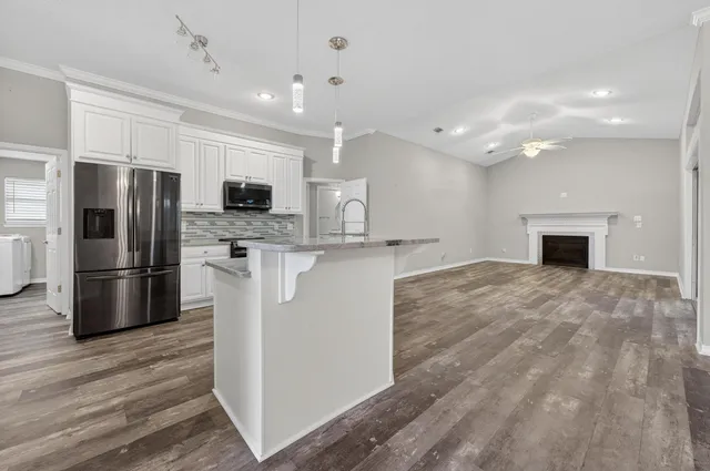 an empty room with wooden floor and fireplace