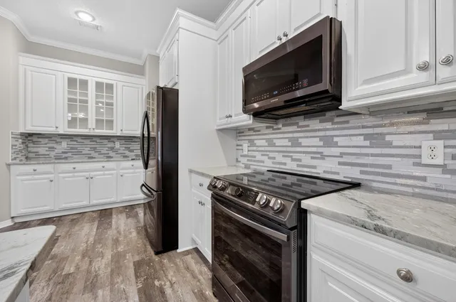 a view of a room with wooden floor and ceiling fan