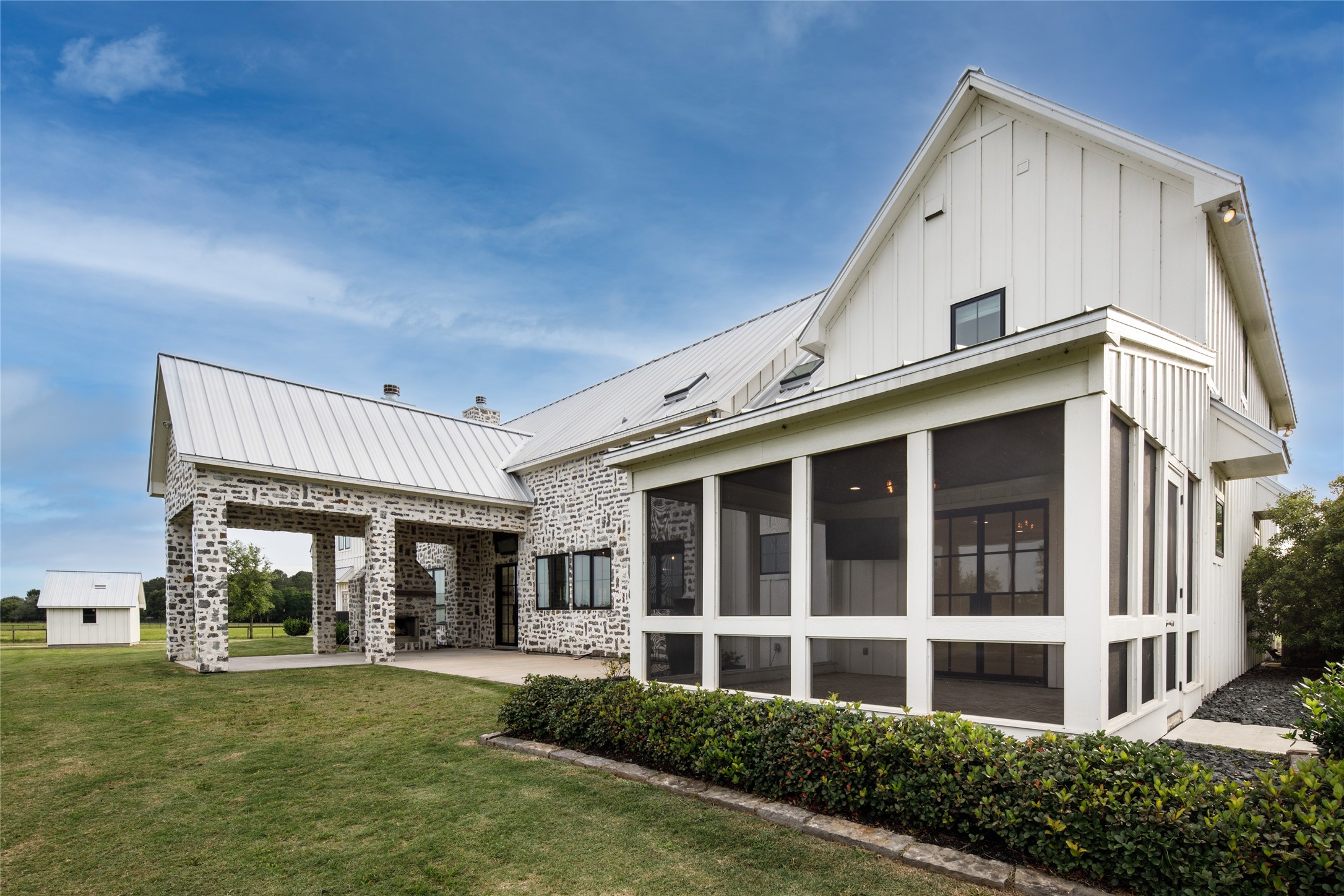 24118 Margerstadt Road Hockley, TX 77447 - Photo 32 of 46 The rear elevation highlights the scale of the home’s screened outdoor living spaces, expansive window lines, and covered gathering areas overlooking the surrounding pasture. Positioned across the back of the residence, the layout allows the outdoor spaces to function as a true extension of the home.