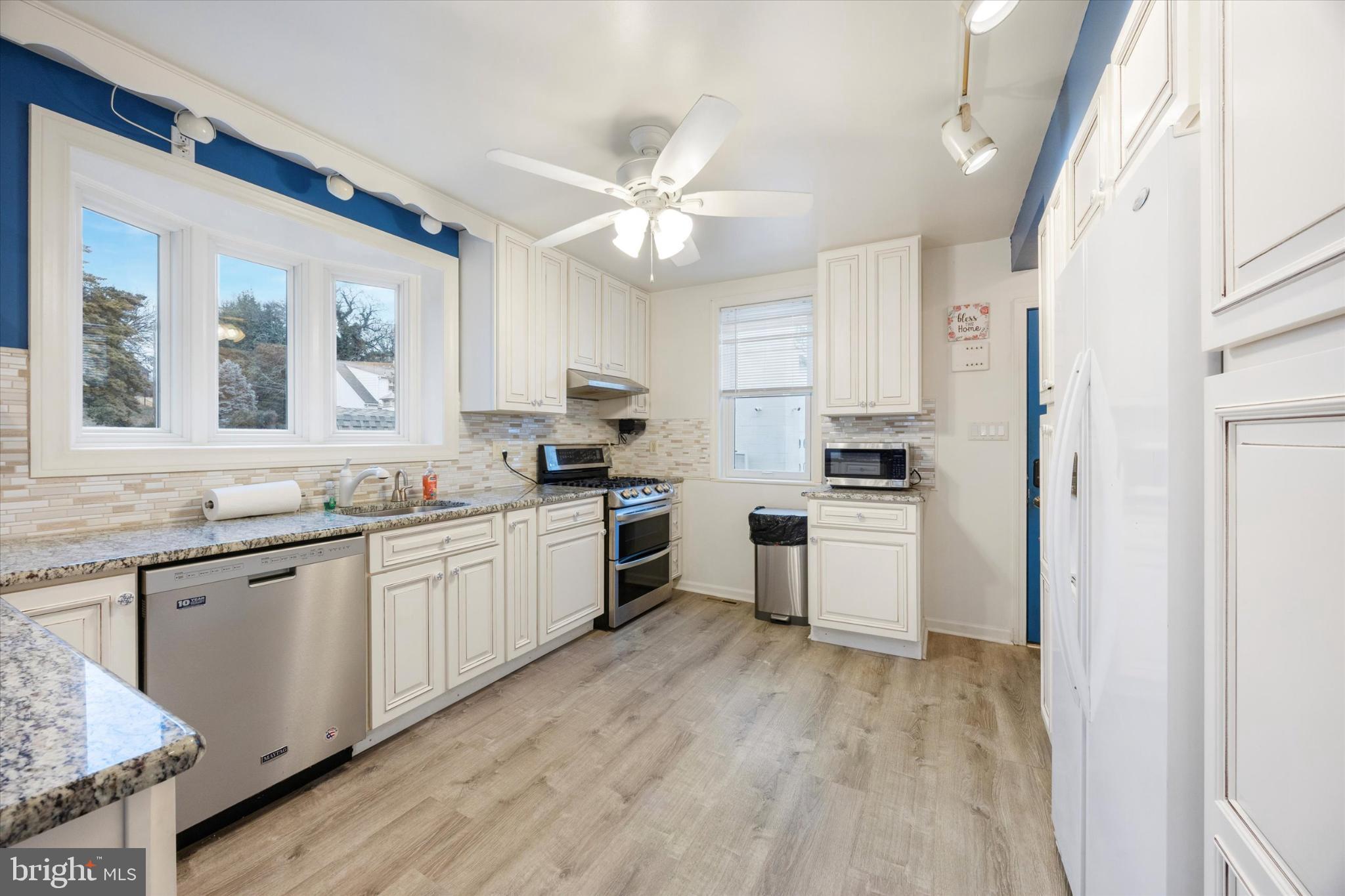 103 Valley Road Wilmington, DE 19804 - Photo 3 of 15 a kitchen with granite countertop a sink cabinets stainless steel appliances and a window