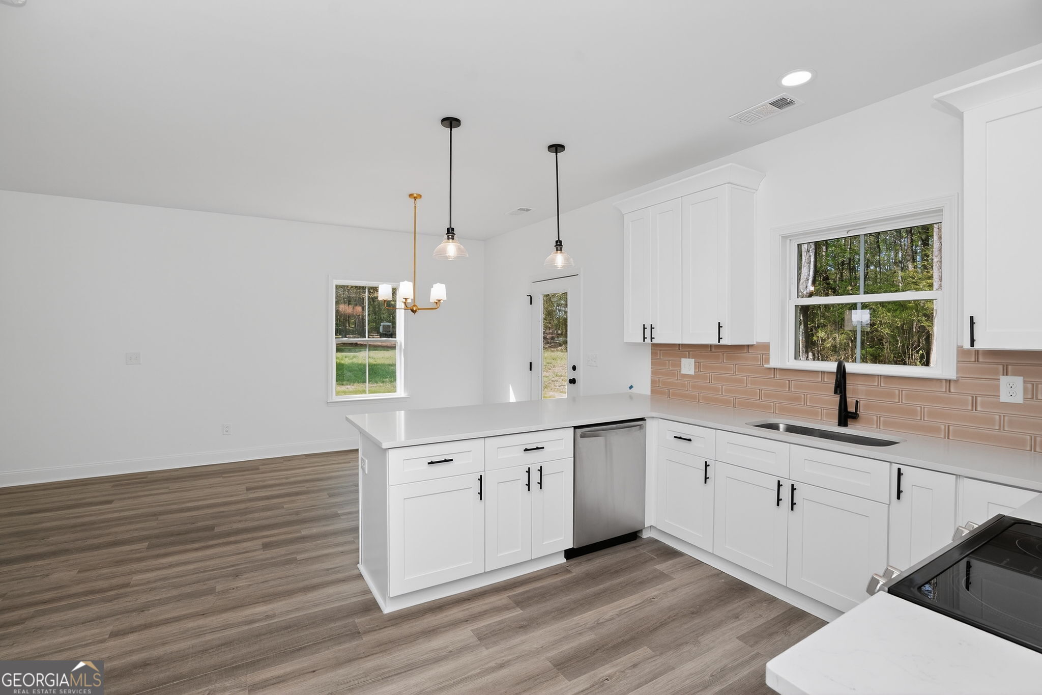 1229 Chappell Mill Road Jackson, GA 30233 - Photo 24 of 55 a large white kitchen with granite countertop a sink a window and stainless steel appliances