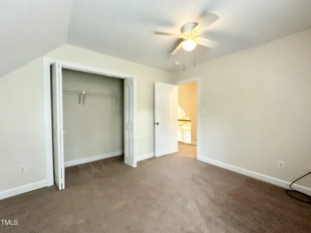 an empty room with a ceiling fan and a window