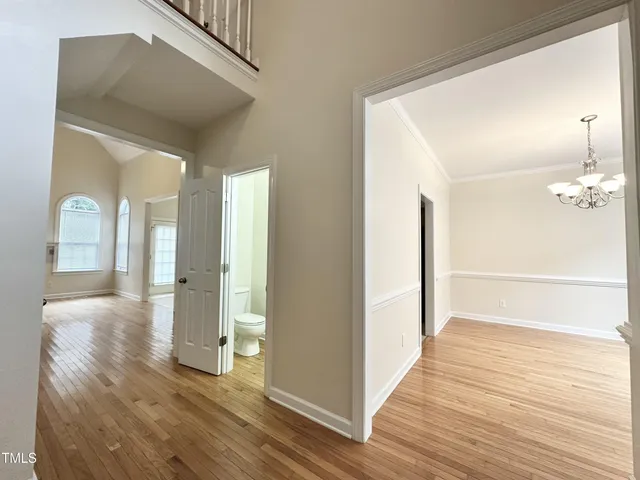 a view of a hallway with wooden floor and staircase
