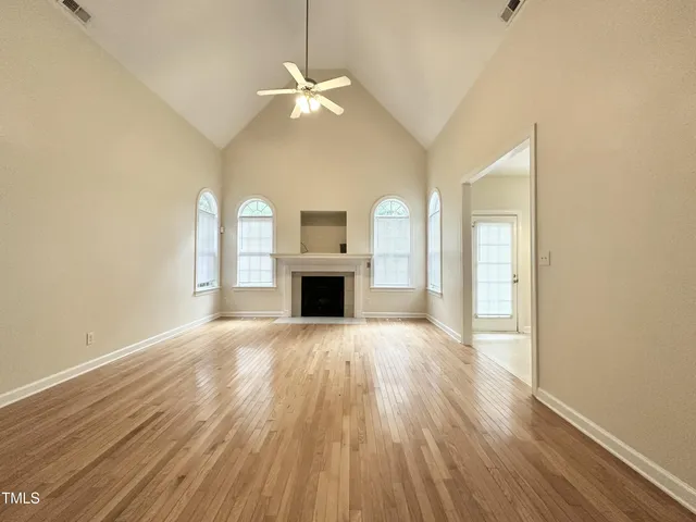 a view of empty room with wooden floor and fireplace
