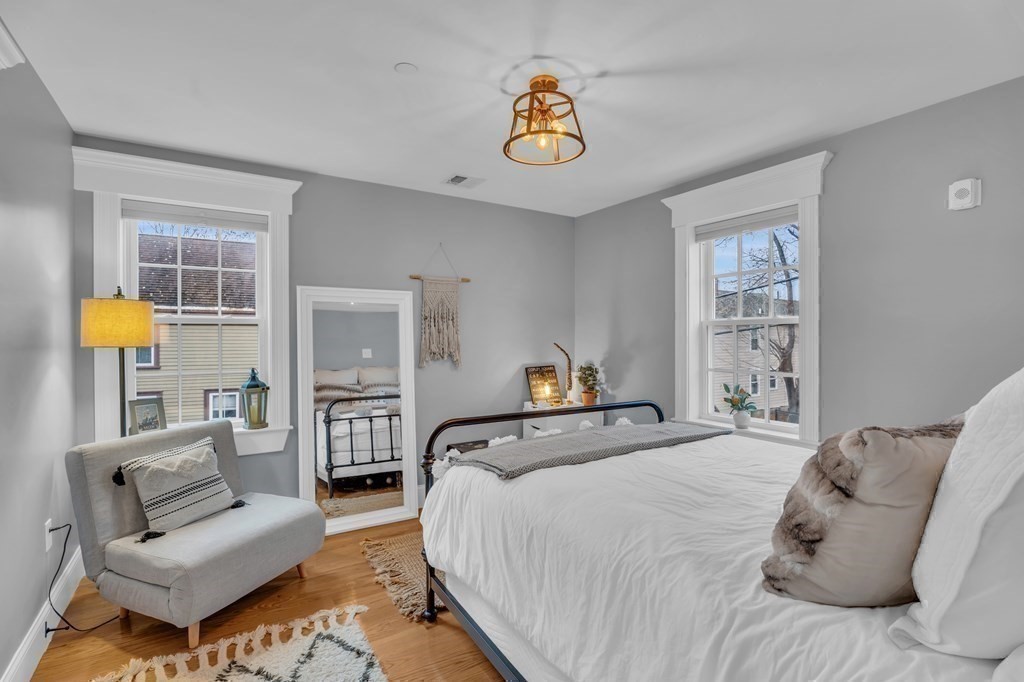106 Bridge Street, Unit 8 Salem, MA 01970 - Photo 16 of 30 a bedroom with a bed a couch and paintings on the wall