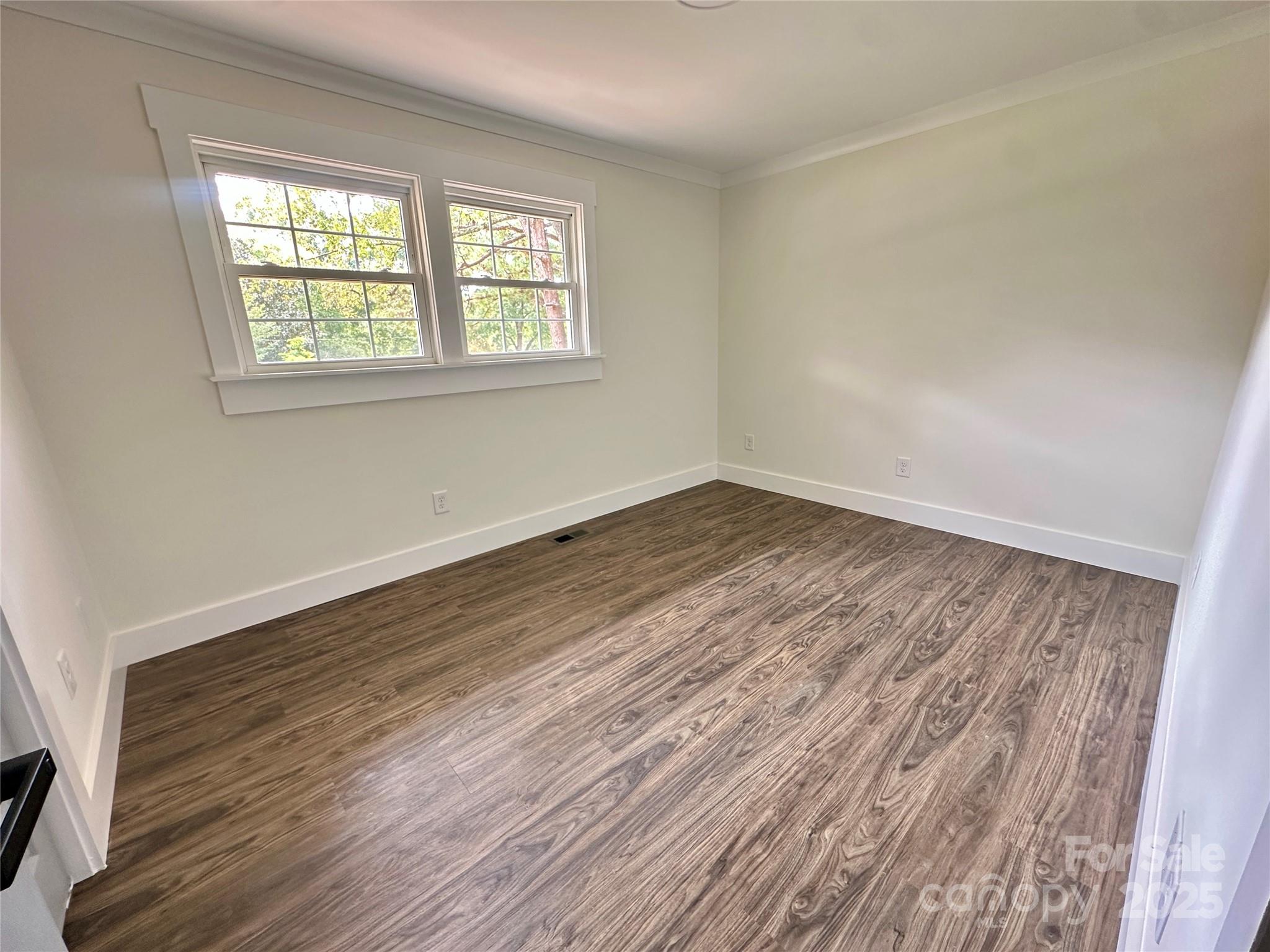 1110 West Edgemont Drive Lancaster, SC 29720 - Photo 18 of 27 a view of an empty room with wooden floor and a window