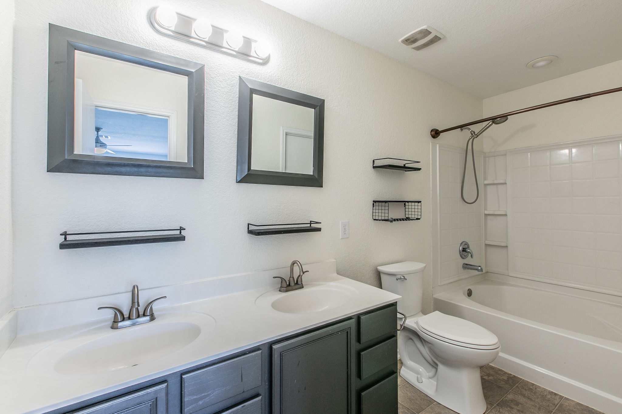 157 Lex Word Kyle, TX 78640 - Photo 18 of 34 Clean lines and dual sinks define this functional bathroom space featuring a tiled tub enclosure.