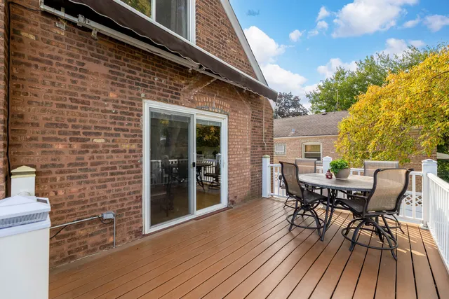 a view of a patio with table and chairs and floor to ceiling window with wooden floor