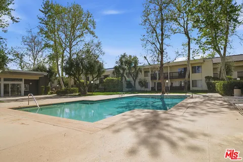 a view of a house with backyard and a tree