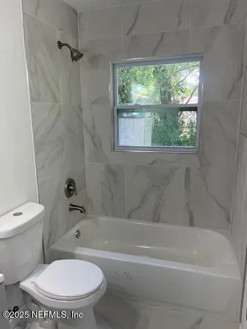 a bathroom with a toilet and a bathtub