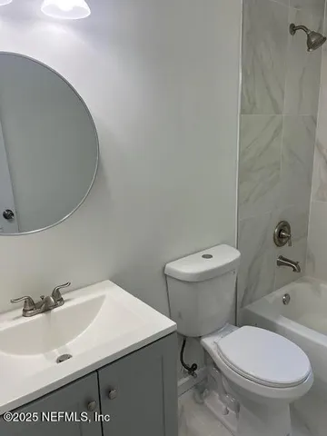 a white toilet sitting next to a bathroom sink