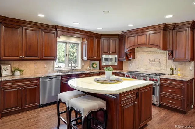 a kitchen with kitchen island granite countertop a sink and chairs