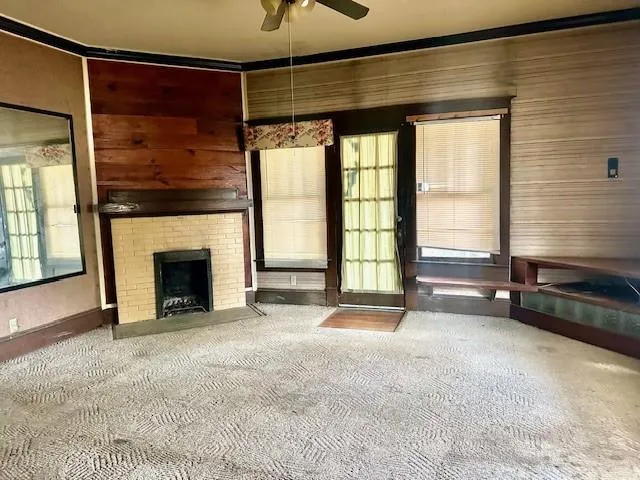 a view of an empty room with a fireplace and a window