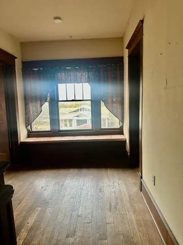 a view of a room with wooden floor and window