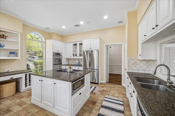 a kitchen with stainless steel appliances granite countertop a sink stove and refrigerator