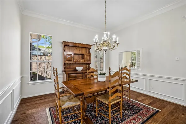 a dining room with furniture a rug and wooden floor