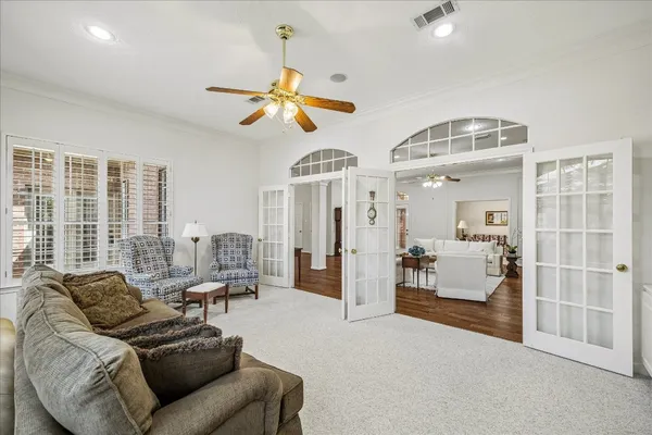 a living room with furniture ceiling fan and a window