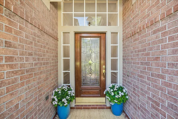 a view of hallway with chandelier and wooden floor
