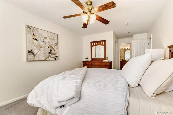 a bedroom with a bed and a painting on the wall