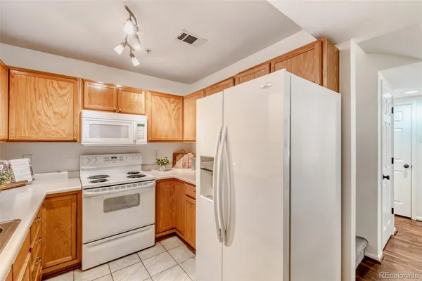 a kitchen with white cabinets and white appliances