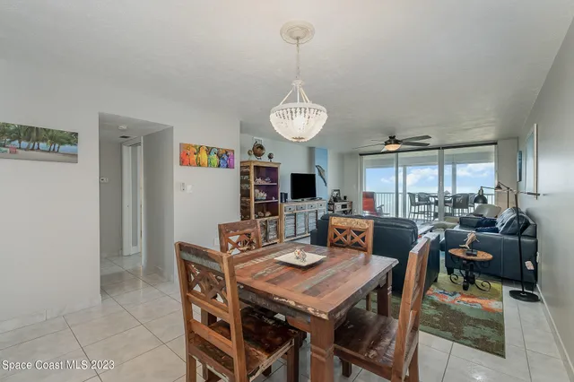 a living room with furniture a flat screen tv and kitchen view