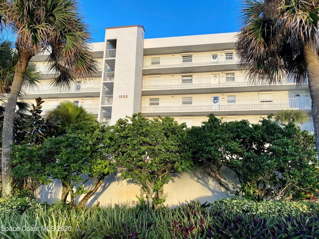 a view of a multi story yard with palm trees