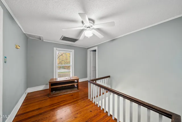 a view of a room with wooden floor and fan