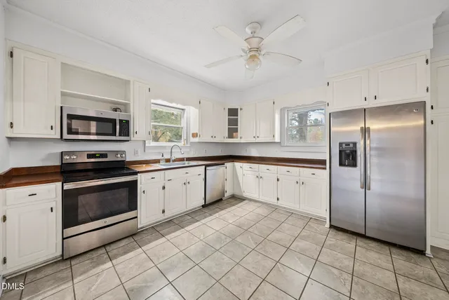a kitchen with stainless steel appliances granite countertop a sink a stove and a microwave