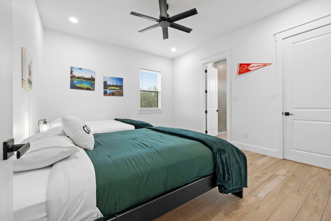 1463 Mountain Valley Road Concan, TX 78838 - Photo 18 of 43 a bedroom with a bed and a chandelier