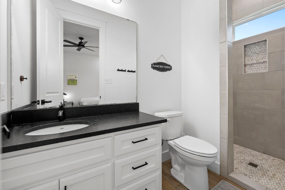 1463 Mountain Valley Road Concan, TX 78838 - Photo 20 of 43 a bathroom with a granite countertop toilet sink and mirror