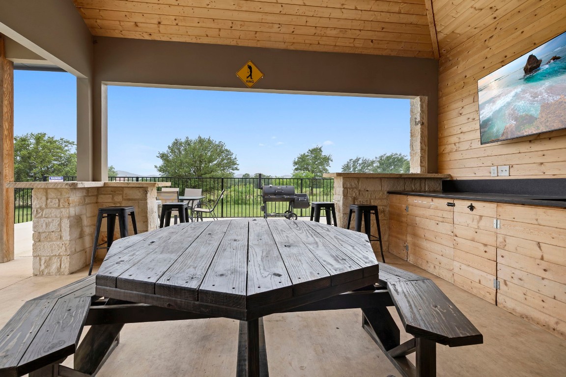 1463 Mountain Valley Road Concan, TX 78838 - Photo 30 of 43 a view of a patio with table and chairs a barbeque with wooden floor and fence