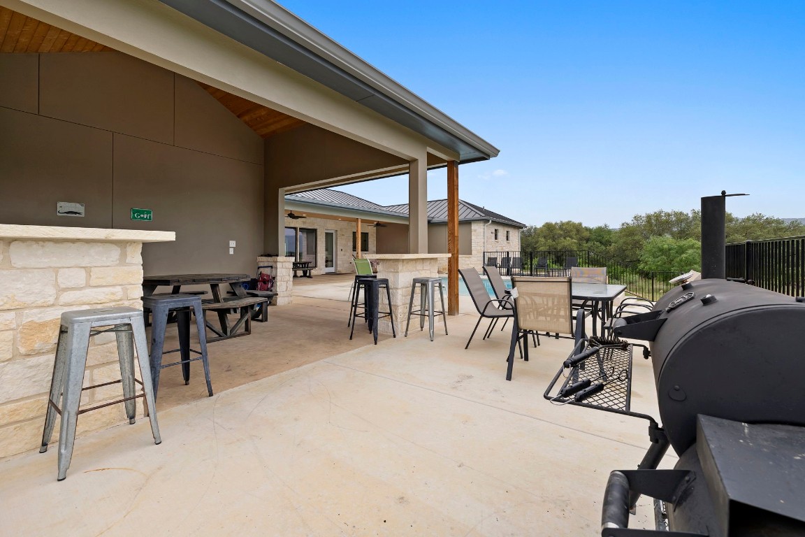 1463 Mountain Valley Road Concan, TX 78838 - Photo 32 of 43 a view of a patio with table and chairs a barbeque with wooden fence and roof