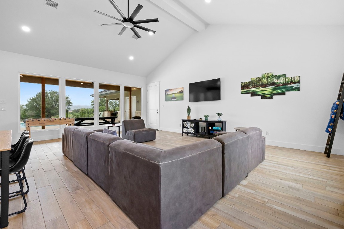 1463 Mountain Valley Road Concan, TX 78838 - Photo 6 of 43 a living room with furniture a flat screen tv and a floor to ceiling window