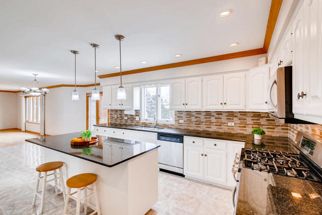 1777 Whispering Court Addison, IL 60101 - Photo 8 of 20 a kitchen with stainless steel appliances granite countertop a sink a stove and a refrigerator