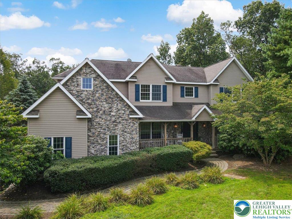 a front view of a house with a yard and lake view