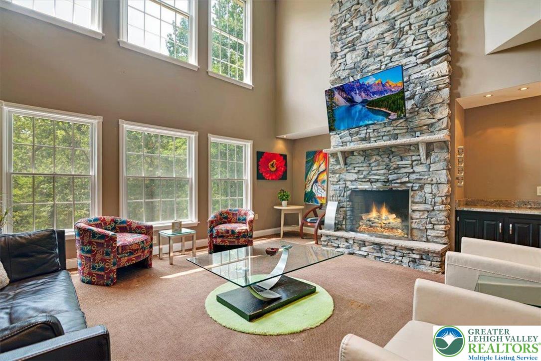 1488 Kelly Road Stroudsburg, PA 18360 - Photo 12 of 89 a living room with furniture a fireplace and a floor to ceiling window