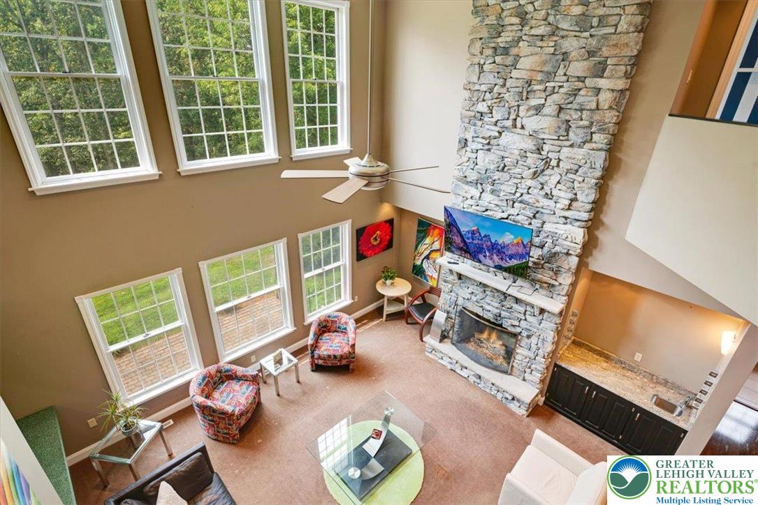 1488 Kelly Road Stroudsburg, PA 18360 - Photo 16 of 89 a living room with furniture a fireplace and a floor to ceiling window