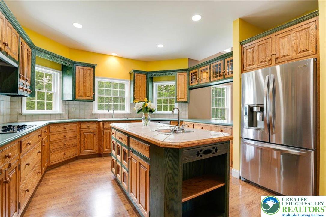 1488 Kelly Road Stroudsburg, PA 18360 - Photo 20 of 89 a kitchen with stainless steel appliances granite countertop a refrigerator a sink dishwasher a stove and a dining table with wooden floor