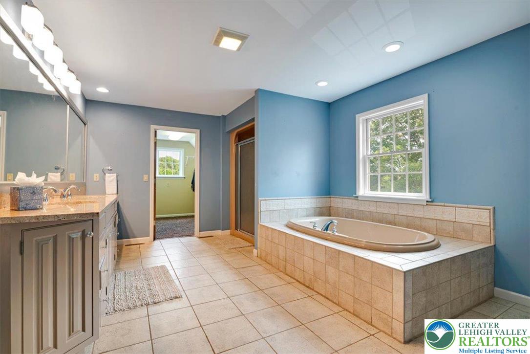 1488 Kelly Road Stroudsburg, PA 18360 - Photo 56 of 89 a spacious bathroom with a tub a sink and mirror