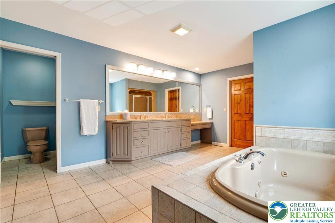 1488 Kelly Road Stroudsburg, PA 18360 - Photo 57 of 89 a spacious bathroom with a tub sink and mirror