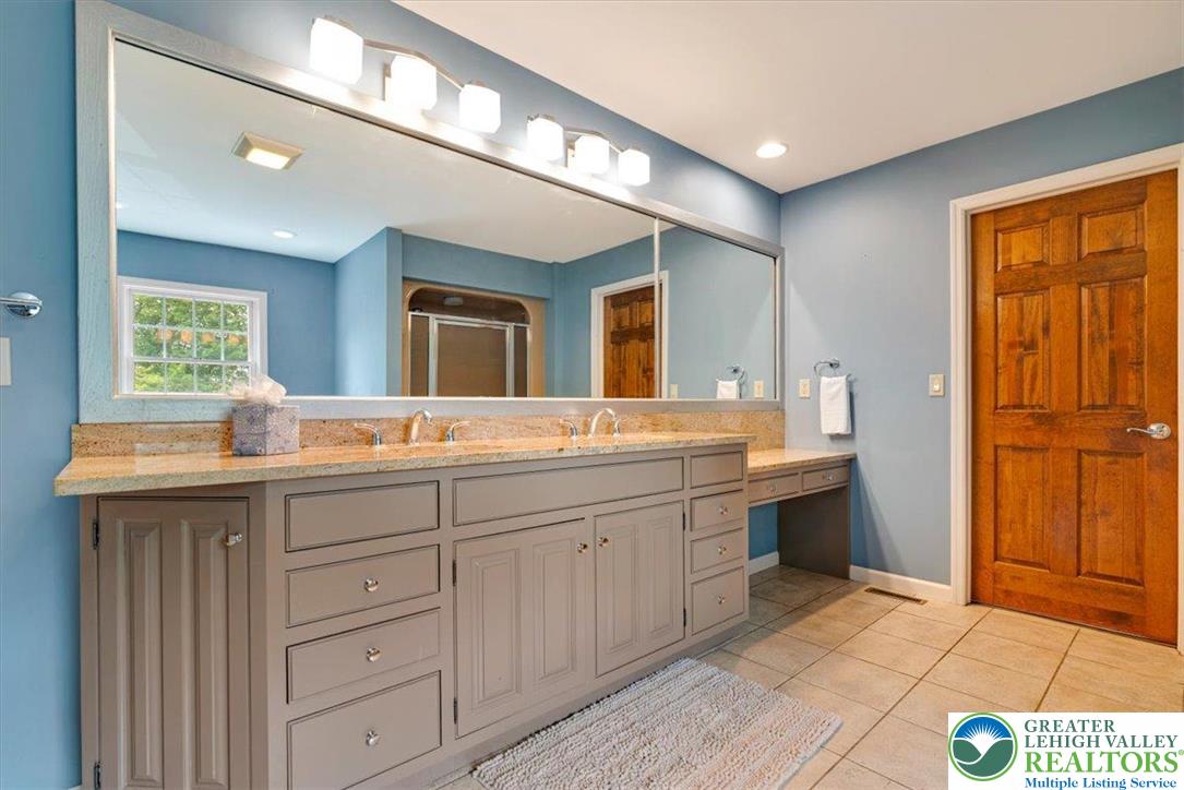 1488 Kelly Road Stroudsburg, PA 18360 - Photo 58 of 89 a spacious bathroom with a granite countertop sink a mirror and a