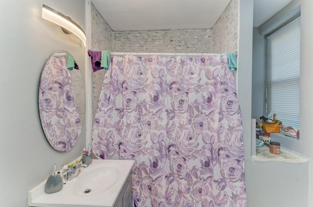 6840 South Prairie Avenue Chicago, IL 60637 - Photo 13 of 47 a bathroom with a sink and a shower curtain