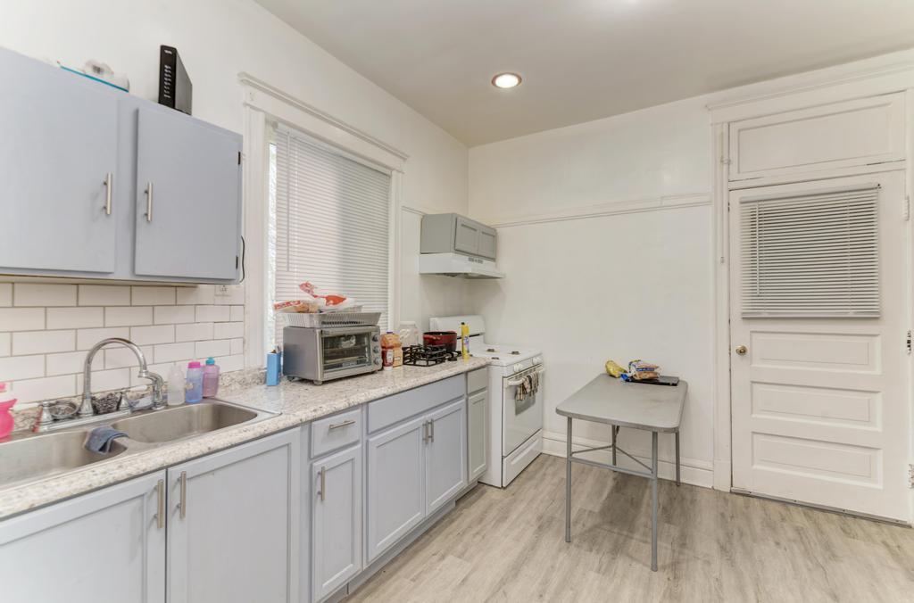 6840 South Prairie Avenue Chicago, IL 60637 - Photo 25 of 47 a kitchen with a sink cabinets and wooden floor