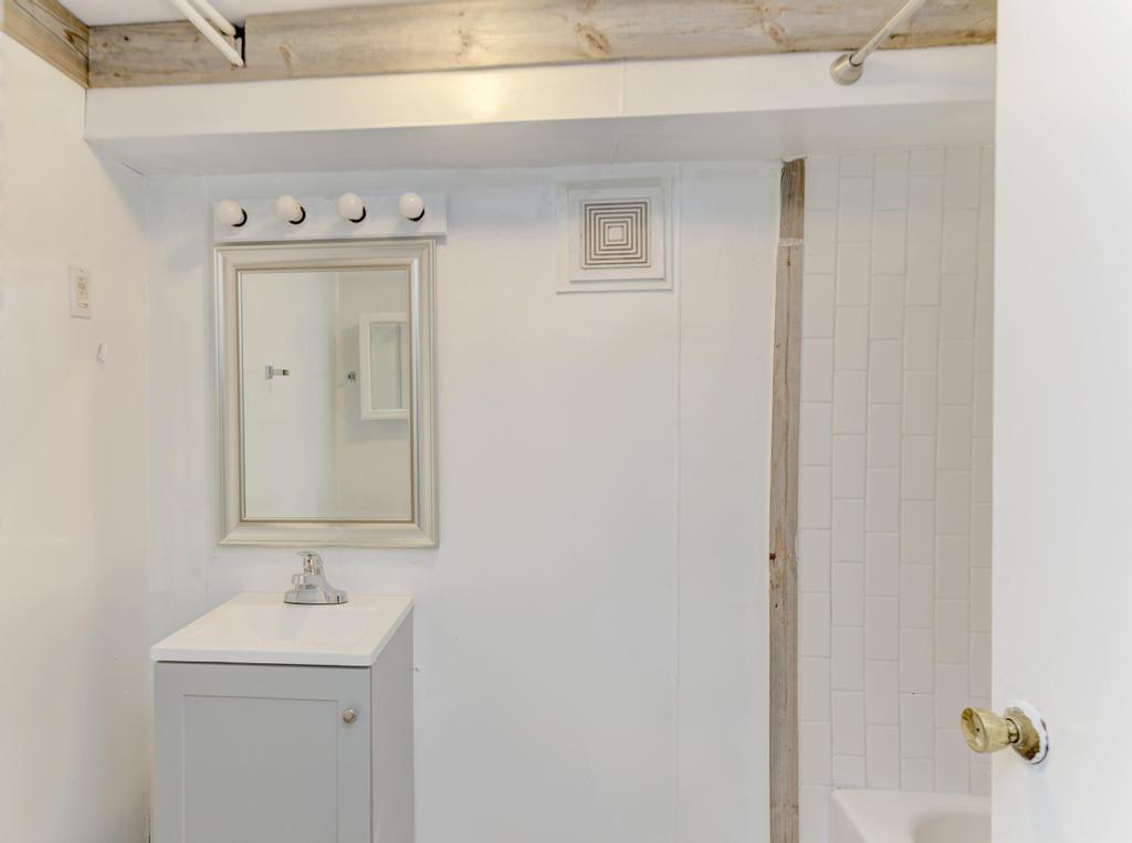 6840 South Prairie Avenue Chicago, IL 60637 - Photo 29 of 47 a bathroom with a sink and mirror with machine