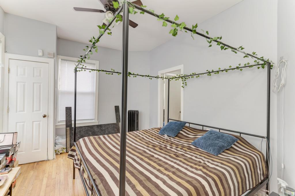 6840 South Prairie Avenue Chicago, IL 60637 - Photo 39 of 47 a bedroom with a bed and a chandelier
